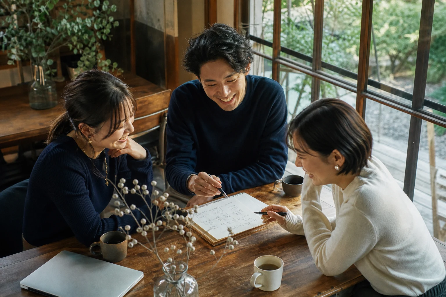 カフェでノートを囲み、会話を楽しむ若い仲間たちのイメージ。AI生成写真
